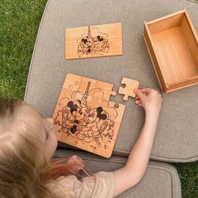 Девочка собирает пазл-мозайку из больших деталей с Микки и Минни Маус